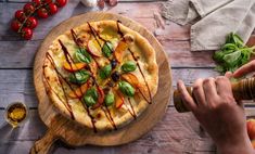 a pizza on a cutting board with sauce drizzled over it