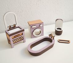 an assortment of wooden toys including a camera, mirror and combing machine on a table