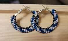 These sakonige (blue in Cherokee) swirl beaded earrings can add a little whimsy to your holiday outfit. Other colors available under "variations". Blue Beaded Round Hoop Earrings, Handmade Blue Beaded Hoop Earrings, Handmade Blue Beaded Small Hoop Earrings, Blue Beaded Small Hoop Earrings, Handmade Blue Round Hoop Earrings, Small Blue Beaded Hoop Earrings, Blue Small Hoop Beaded Earrings With Dangling Beads, Handmade Small Hoop Blue Earrings, Handmade Small Blue Hoop Earrings