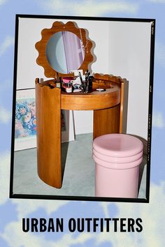 a vanity table with a mirror and pink trash can in front of it that says urban outfitters