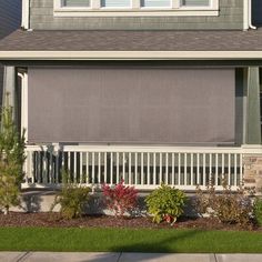 a house with a large front porch and white fence