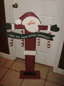 a santa clause standing on top of a red fire hydrant in front of a door