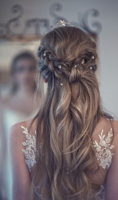 the back of a woman's head with long hair in a half - up braid