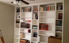 a ladder is leaning against a bookshelf in a room with white shelving