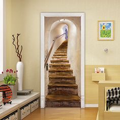 an open door leading to a stairway in a room with wooden floors and white walls