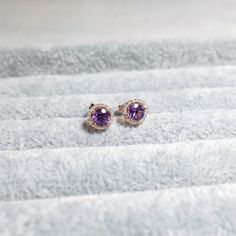 These stylish earrings have a stunning bright color and the Amethyst is surrounded by a halo of shimmering diamonds. Perfect as a gift for yourself, your girlfriend or wife, or your mother. Made to Order.  * Metal: 925 Sterling Silver  Custom Color: Gold Vermeil in 18K Rose Gold/ 18K Yellow Gold, Sterling Silver Main Stone: Amethyst, 5mm dia Round Shape, 2pcs Side Stone: Cubic Zirconia, 36pcs * Metal: 14K Custom Colors: Yellow Gold, Rose Gold, White Gold Main Stone: Amethyst, 5mm dia Round Shape Stone Studs, Stylish Earring, Birthstone Gifts, Purple Stones, Diamond Earrings Studs, Gold Vermeil, Halo, Diamond Earrings, Natural Gemstones