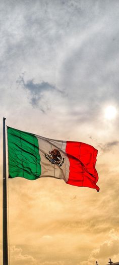 the mexican flag is flying high in the sky