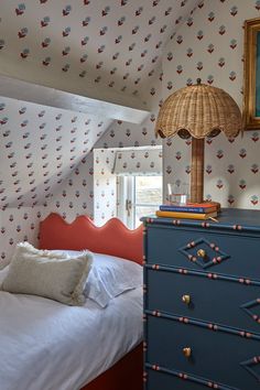 a bedroom with a blue dresser and wallpaper on the walls next to a bed