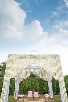 an outdoor wedding ceremony setup with pink chairs