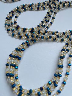 Single Strand Waist Bead - Woroba is a timeless piece inspired by the rich traditions of Ivory Coast. Meticulously handcrafted from 100% glass beads, this waist bead exudes authenticity and artistry. The deep blue color of the beads reflects the serene beauty of the Ivory Coast, adding an element of tranquility and depth to your ensemble. Each bead is a testament to the skilled craftsmanship of the artisans, showcasing the cultural richness of the region. Accentuating this single strand are silv Elegant Waist Beads With Spacer Beads As Gift, Blue Spacer Beads For Festivals, Elegant Waist Beads With Spacer Beads For Gift, Blue Czech Glass Beaded Chain, Traditional Blue Faceted Beads, Elegant Blue Faceted Beads, Multi-strand Polished Czech Glass Beads, Blue Beaded Rondelle Jewelry, Blue Multi-strand Elegant Beads