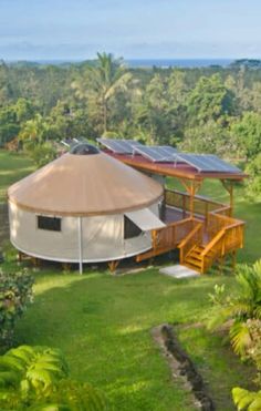 an aerial view of a yurt with solar panels on the roof and stairs leading up to it