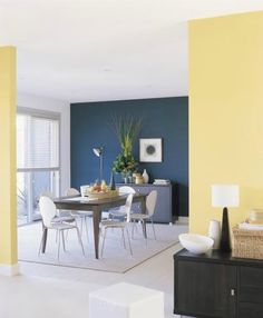 a dining room with yellow walls and white chairs