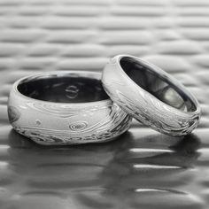 two wedding rings sitting on top of a table