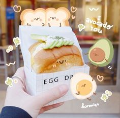 someone holding up an egg dp sandwich in front of a window with stickers on it