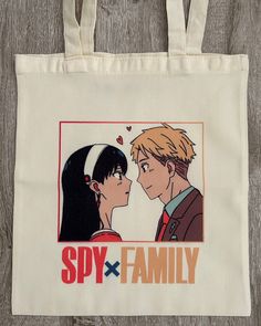 a tote bag with an image of two people kissing and the words spy x family printed on it