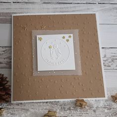 a card with gold stars on it and a pine cone