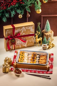 an assortment of christmas treats on a table next to some decorations and gifts for the holiday season