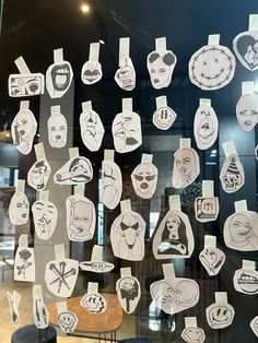 a bunch of cut out faces on a glass window