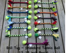 several tennis balls are arranged in the shape of an arrow on a wooden floor with string and tags attached to them