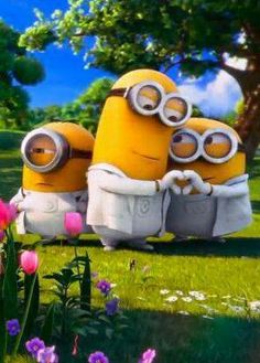 two minions sitting on top of each other in the grass with trees and flowers behind them