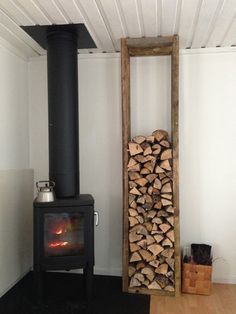 a wood burning stove in the corner of a room with white walls and wooden floors