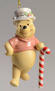 a winnie the pooh ornament hanging from a christmas tree with candy cane