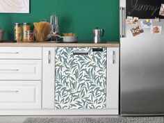 a kitchen with green walls and white cupboards next to a silver refrigerator freezer