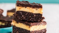 three pieces of chocolate cake sitting on top of each other in front of a blue bowl