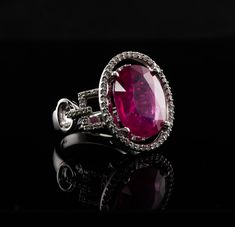 Diamond Pink Ruby Ring, 14K White Gold Oval (6.16ct) Ruby. This gorgeous vintage estate ring is finely crafted in solid 14K White gold and set with natural Earth mined Pink Ruby and genuine diamonds.  The center oval cut gem measures 14mm x 11mm (6.16 carats).  This is a very good quality stone with great intensity and strong brilliance.  The center stone is surrounded by 44 diamonds plus 26 diamonds on the sides. These diamonds are SI clarity and H color totaling (.70cttw) The top of the ring measures 19mm x 16mm.  Size 6.5 (can be sized).  The ring weighs 8.4 grams.  Great estate condition. * * * * * * * * PLEASE, READ DESCRIPTIONS CAREFULLY. Choose ACCORDINGLY. We want you to be completely satisfied with your purchase. If for any reason you are not entirely pleased, simply return the it Luxury Oval Ruby Ring, Luxury Oval Ruby Ring With Gemstone, Luxury Oval Ruby Ring With Center Stone, Luxury Ruby Ring With Oval Center Stone, Luxury Oval Ruby Ring With Prong Setting, Luxury Oval Ruby Ring For Formal Occasions, Elegant Gia Certified Oval Ruby Ring, Elegant Oval Ruby Ring With Vvs Clarity, Ruby Ring Vintage