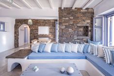 a living room filled with furniture and stone walls