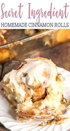 a white plate topped with cinnamon rolls covered in icing and sitting on a wooden table