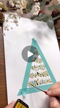 someone is painting a christmas tree on a piece of paper