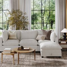 a living room with white furniture and large windows