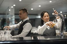 a man and woman are behind the bar