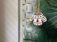 a wooden ornament hanging from a pine tree