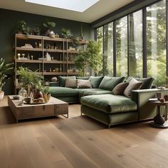 a living room filled with lots of furniture and plants on top of wooden flooring