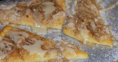 four pieces of pizza sitting on top of a pan covered in powdered sugar and icing