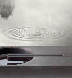 an artistic photo of water with ripples in the middle and reflection on the surface