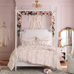 a white bed sitting in a bedroom next to a pink wall