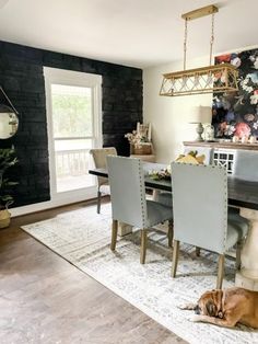 a dog laying on the floor in front of a dining room table