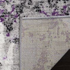 an area rug with purple and white designs on it