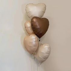 five heart shaped balloons are hanging on the wall