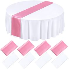 pink and white table cloths on top of a round table with matching napkins