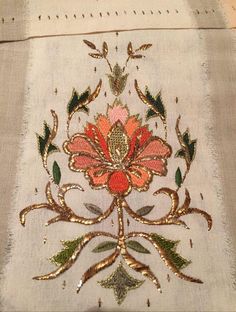 an embroidered cloth with flowers and leaves on it