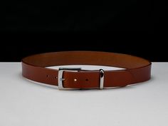 "Luxurious handmade English Bridle leather belt with solid brass buckle. Full grain leather with a firm temper. The Opus (~Grand Work) belt range is our formal style offering, made with a square-style buckle and stylish English Point belt tip. Designed for daily use with formal business wear in mind. The Opus belt involves over 26 individual steps to size, cut, shape, colour, seal and assemble your belt. Are all these steps necessary? Not at all. Do they improve the quality and build of the belt? You bet they do. From slightly reducing the strap thickness at the buckle to reduce bulkiness and allowing the buckle to sit flatter to rounding, sanding and dying the strap edges for comfort and style. Have we cut any costs and settled for sub-par materials used? Never. The thick single piece lea English Bridle, Work Belt, Nice Belts, Business Wear, Formal Business, Beautiful Belts, Traditional English, Brass Buckle, Formal Style