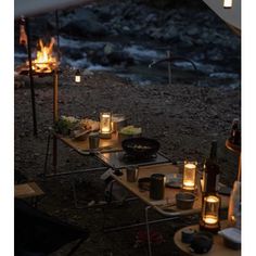 an outdoor table with candles and food on it