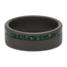 a wedding ring with green and gold inlays on it's black ceramic