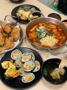 a table topped with lots of different types of food and plates filled with sushi