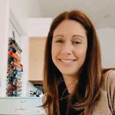 a woman smiling in front of some crochet hooks