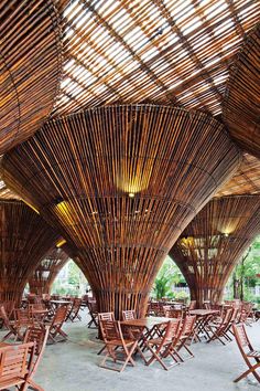 many wooden chairs and tables are lined up in a room with large bamboo screens on the ceiling